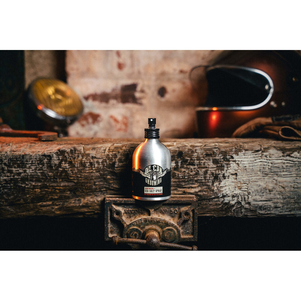 Oil Can Grooming Benchmark Sea Salt Spray, botella sobre viga de madera en taller