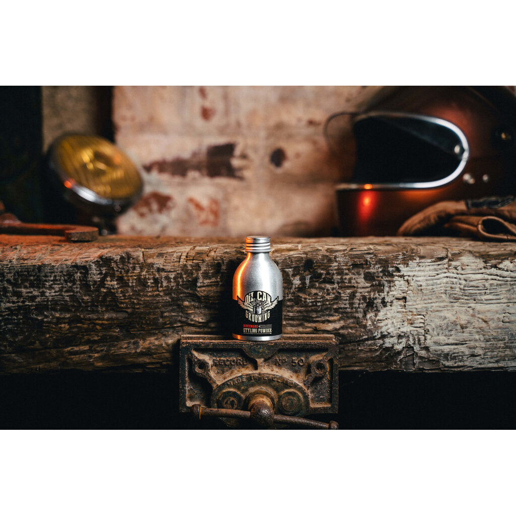 Oil Can Grooming Benchmark Styling Powder, bote sobre viga de madera en taller