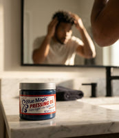 Blue Magic Pressing Oil - tarro en el lavabo, hombre con pelo rizado frente al espejo