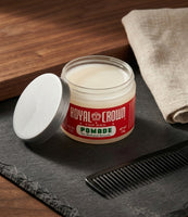 Royal Crown Pomade - tarro abierto sobre pizarra con peine, la pomada blanco crema visible