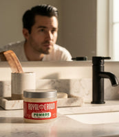 Royal Crown Pomade - tarro en el lavabo, hombre con slick back frente al espejo