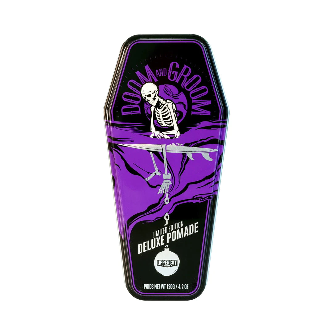 Uppercut Doom & Groom Deluxe Pomade, vista frontal de la lata morada en forma de ataúd sobre fondo blanco.